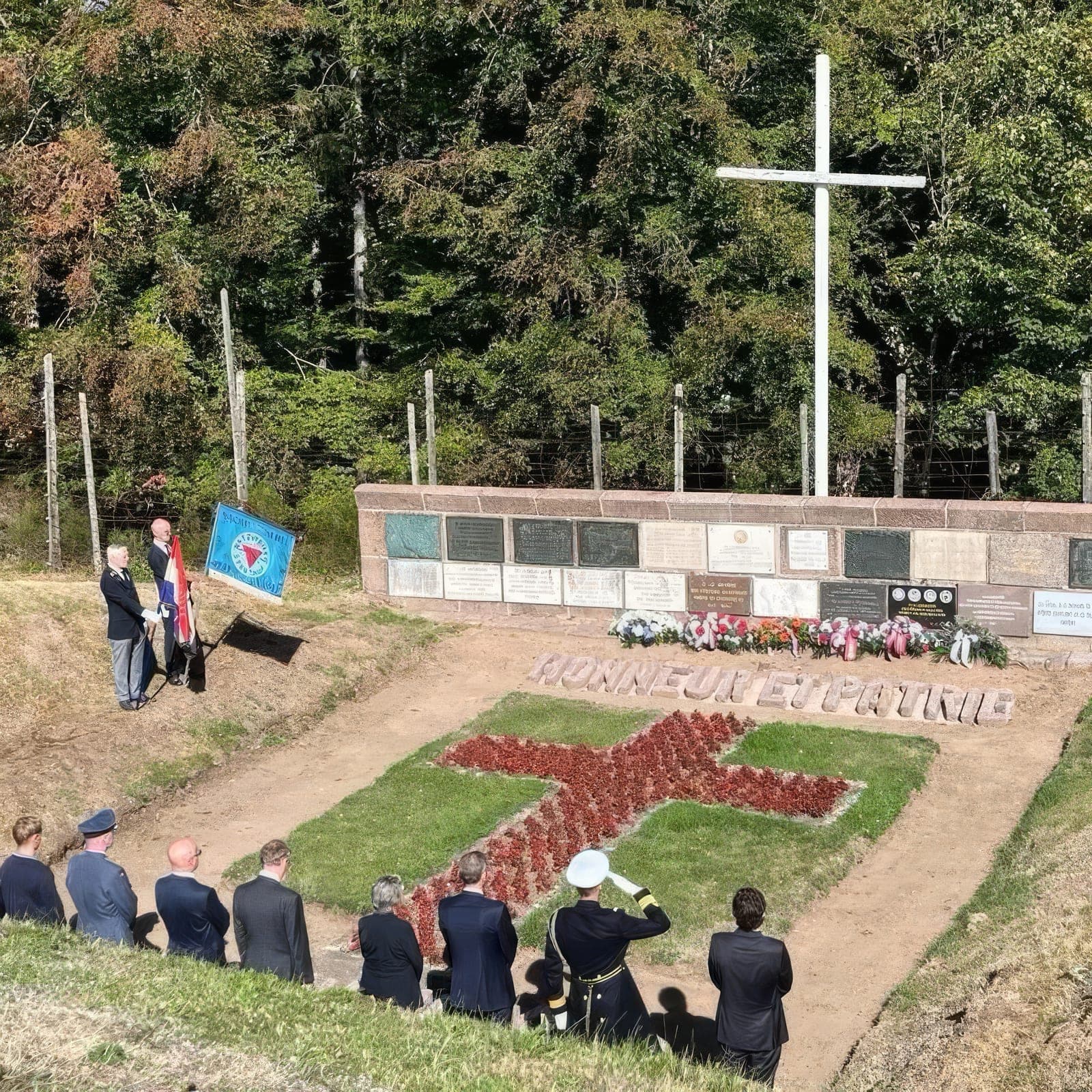 Askegraven etter kransenedleggelsen, med teksten «Honneur et Patrie»