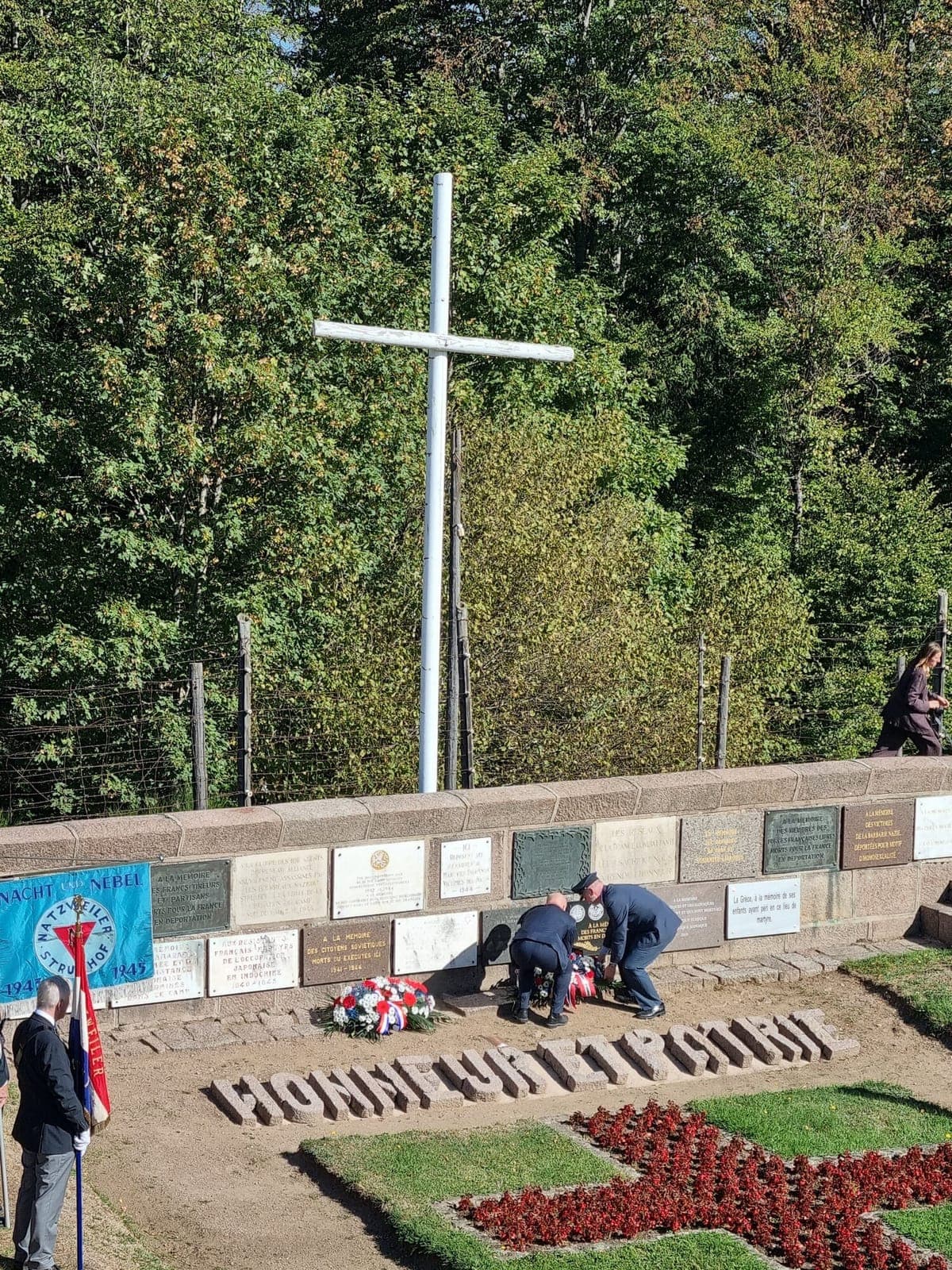 Kransene legges ned ved minnetavlene over askegraven, med «Honneur et Patrie» i steinskrift