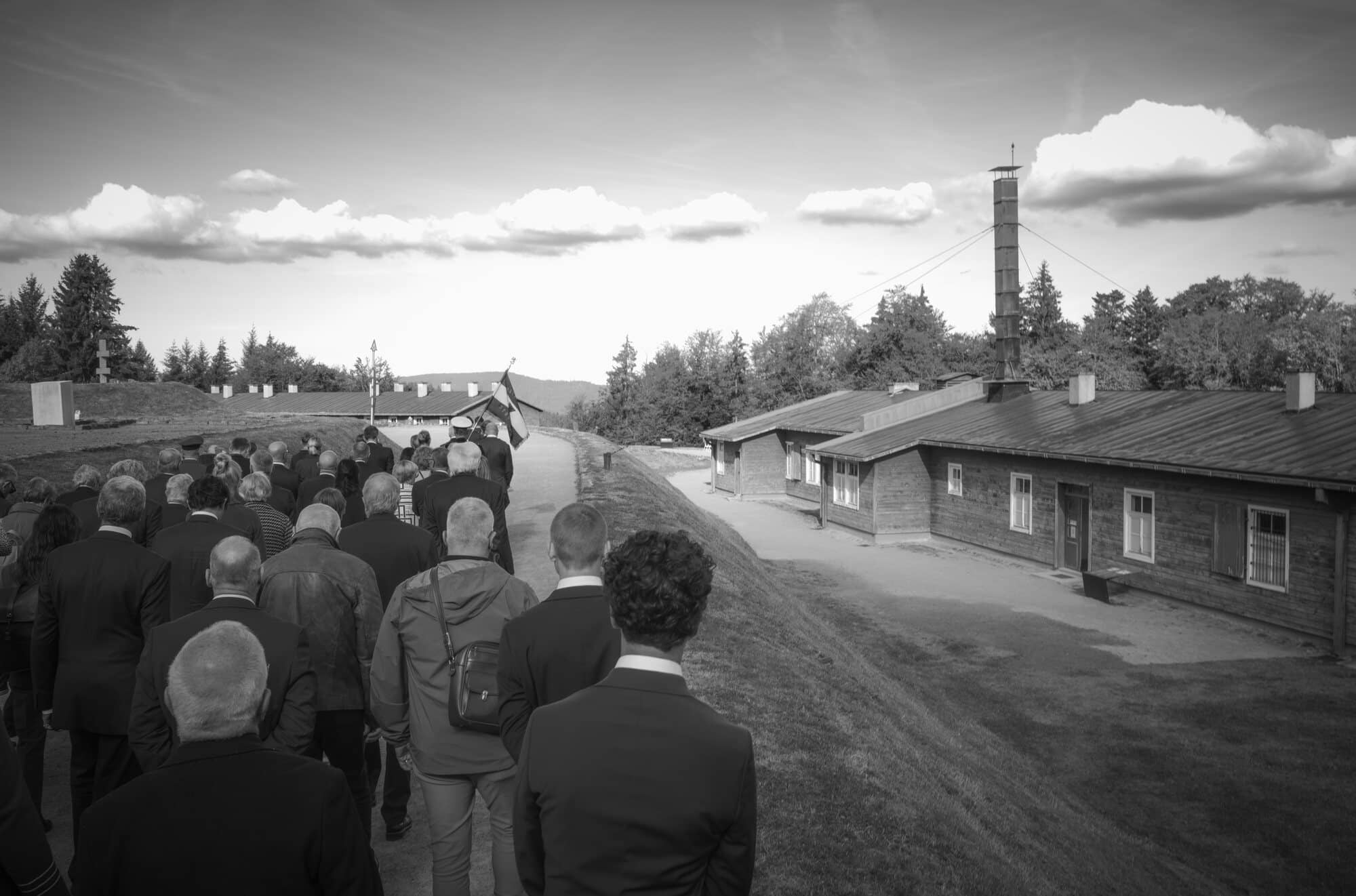 Følget går ned gjennom leiren i Natzweiler-Struthof mot brakkene og krematoriepipa, 12. september 2026. Foto: Torgeir W. Sørbye