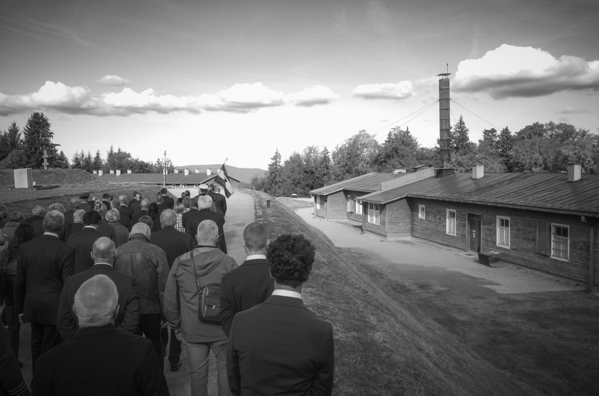 Følget går ned gjennom leiren i Natzweiler-Struthof mot brakkene og krematoriepipa, 12. september 2026. Foto: Torgeir W. Sørbye